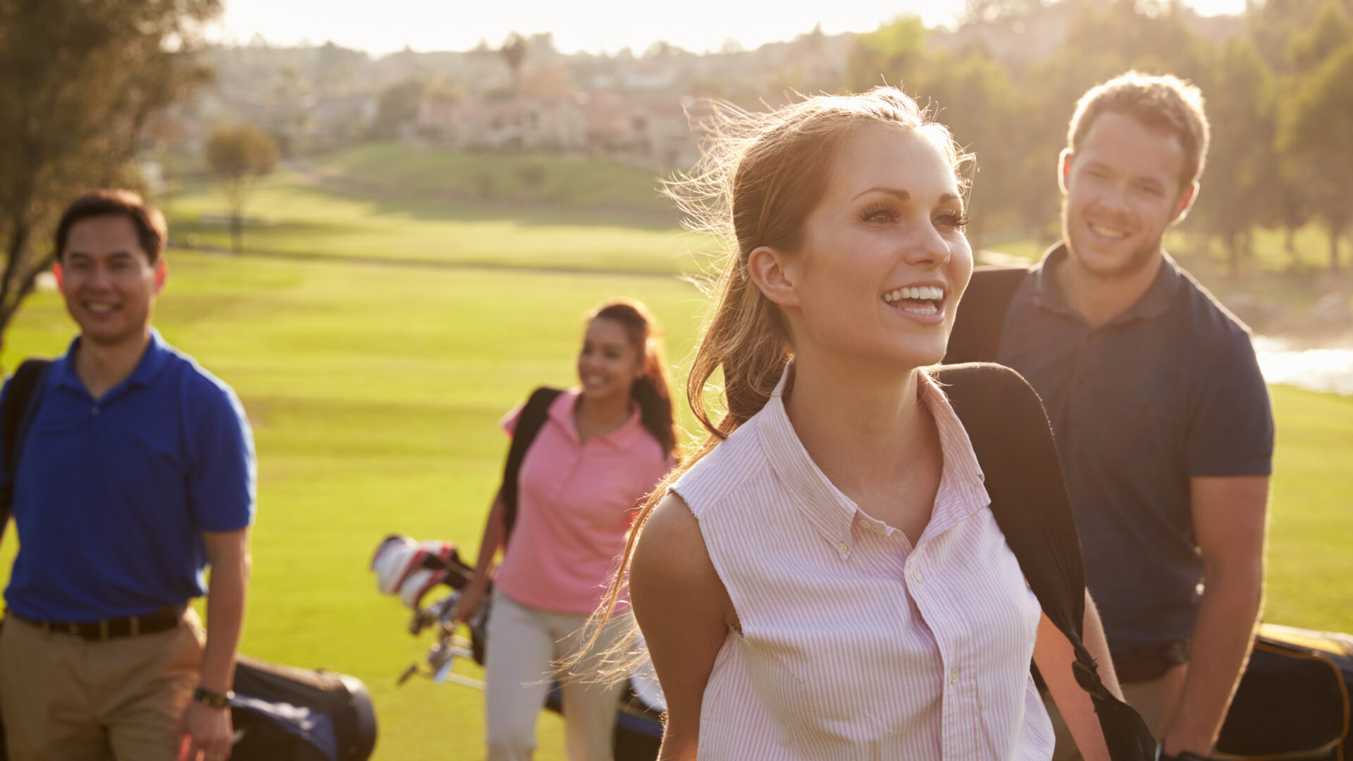 Un groupe de golfeurs marchent sur un terrain et portent des clubs de golf