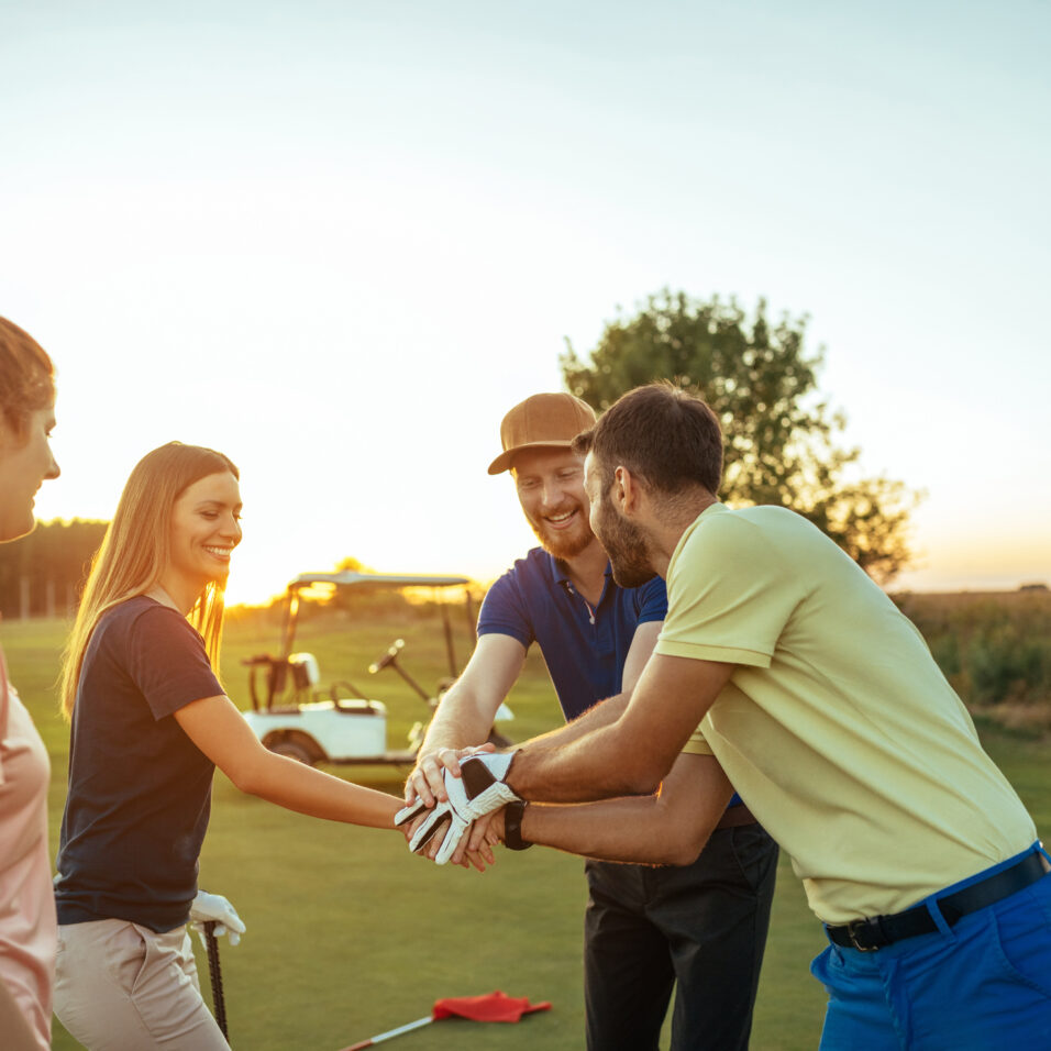 Un groupe d'amis célèbrent sur un terrain de golf