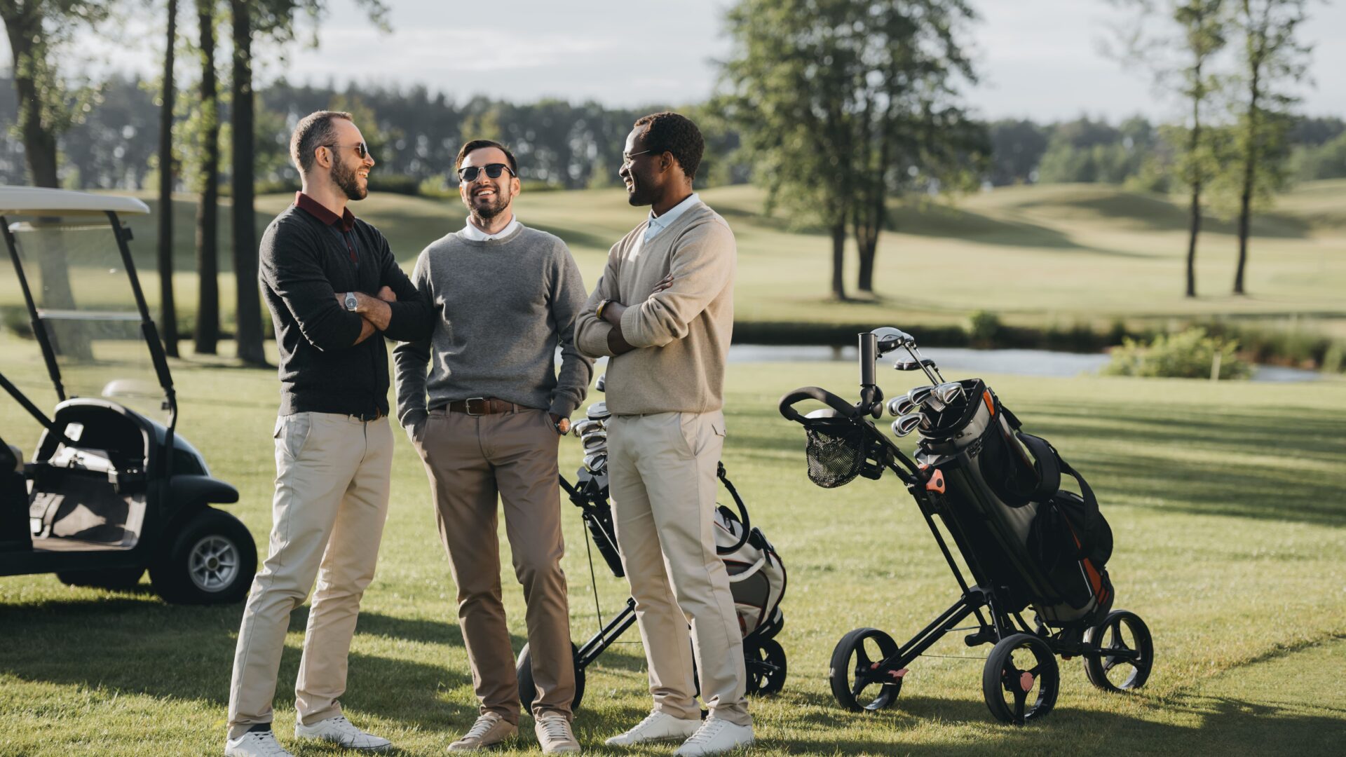 Amis discutant sur un terrain de golf avec des caddies et des clubs